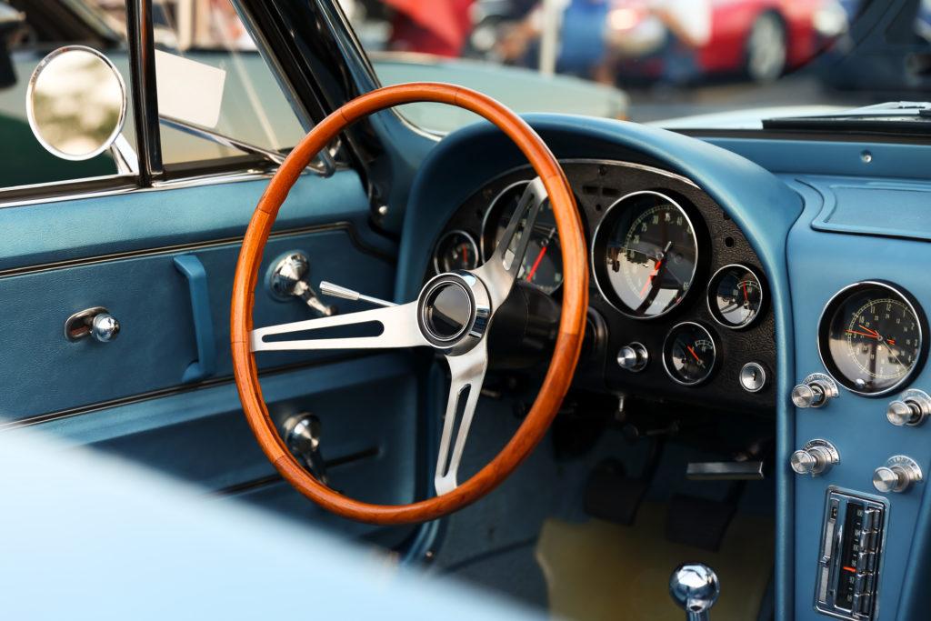 Restored classic car interior with wood-rimmed steering wheel and original gauges