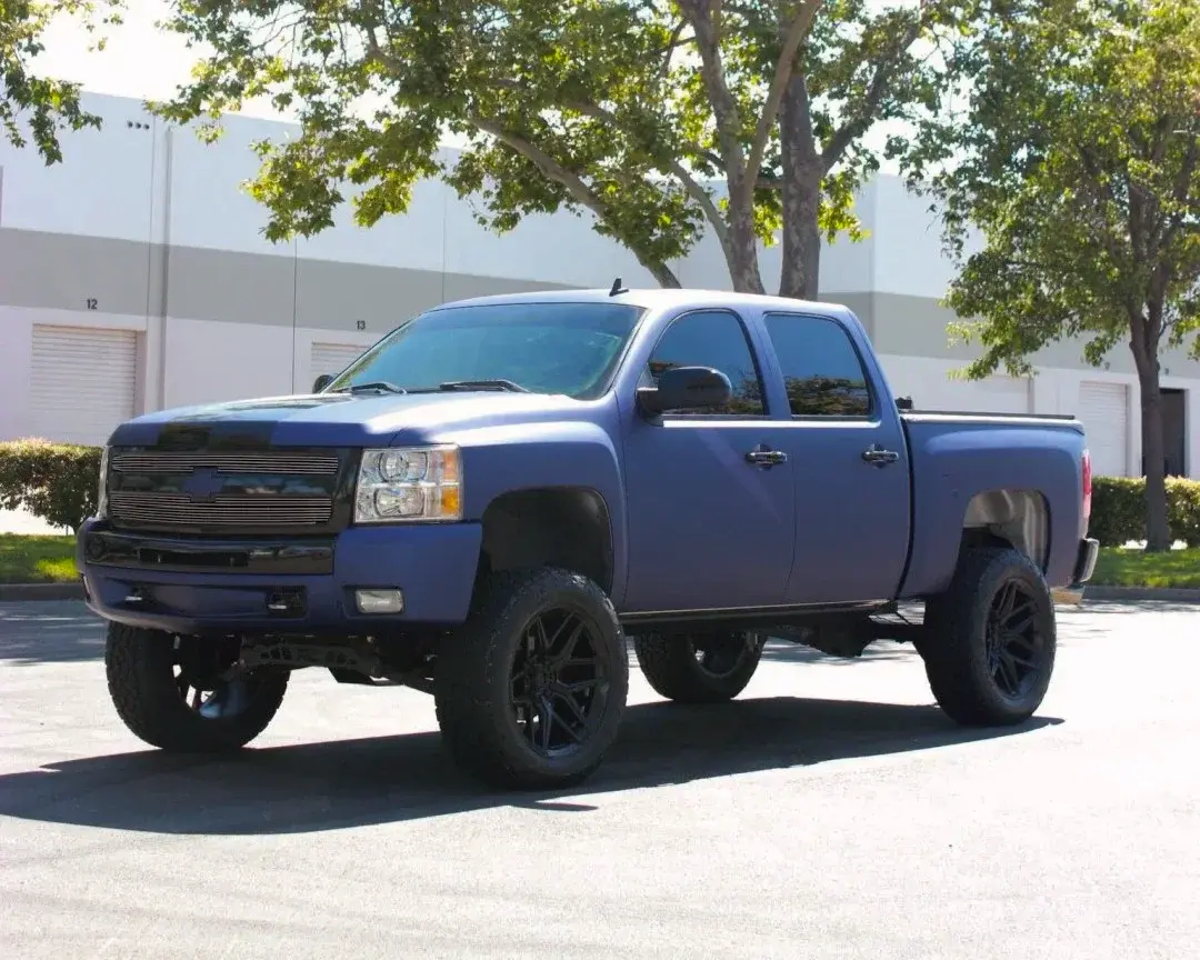 2025 GMC Sierra 1500 wrapped in glossy charcoal vinyl at a Cincinnati vehicle wrap shop after-and-before view